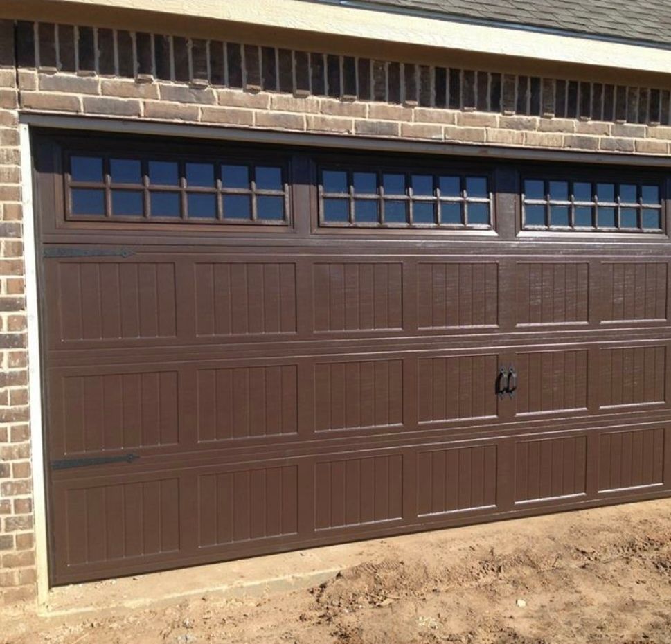 Brown garage door with windows, brick trim.