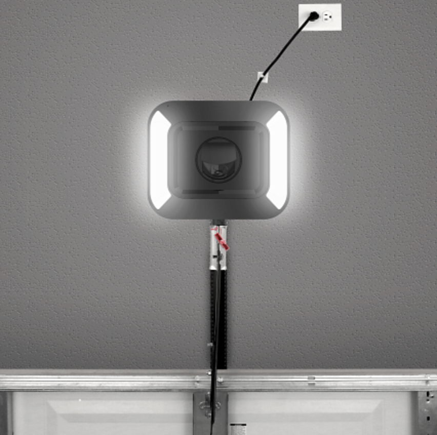 Garage door opener with a black and gray housing and a red light.