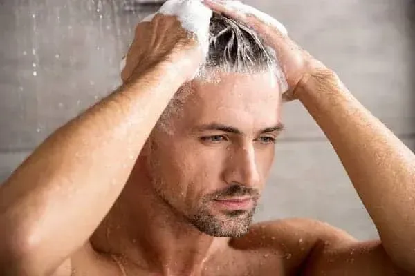 Man gently washing his hair with shampoo