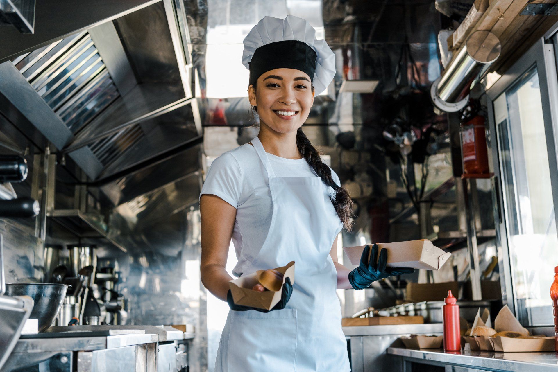 Chef holding food plates inside a food truck