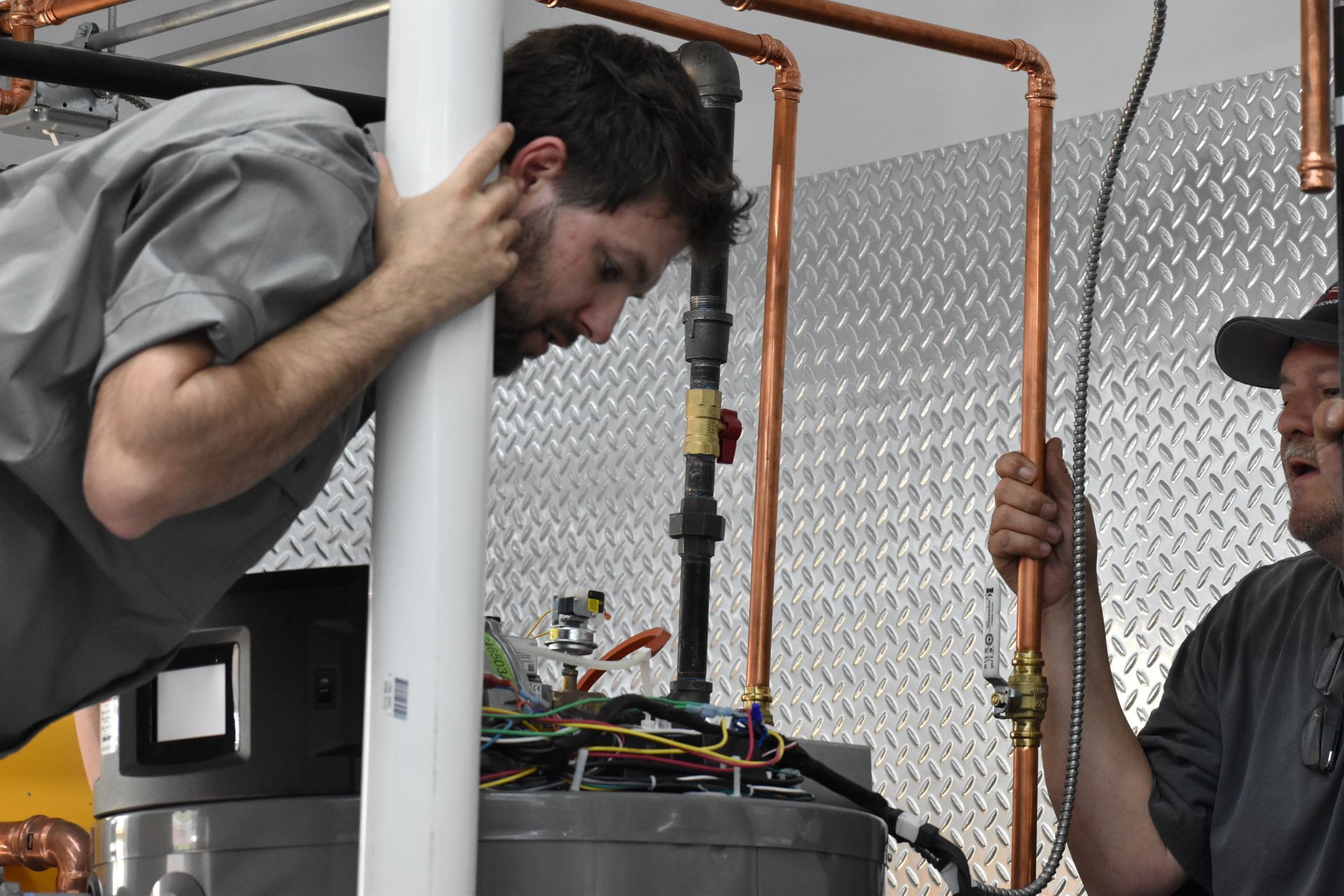 Technician examining Rheem Triton, performing commercial water heater repair