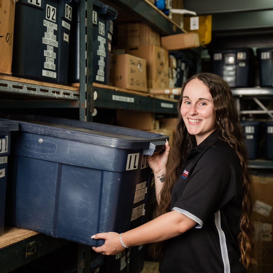 Erin grabbing an A.O. Smith Commercial Water Heater Parts Service Bin