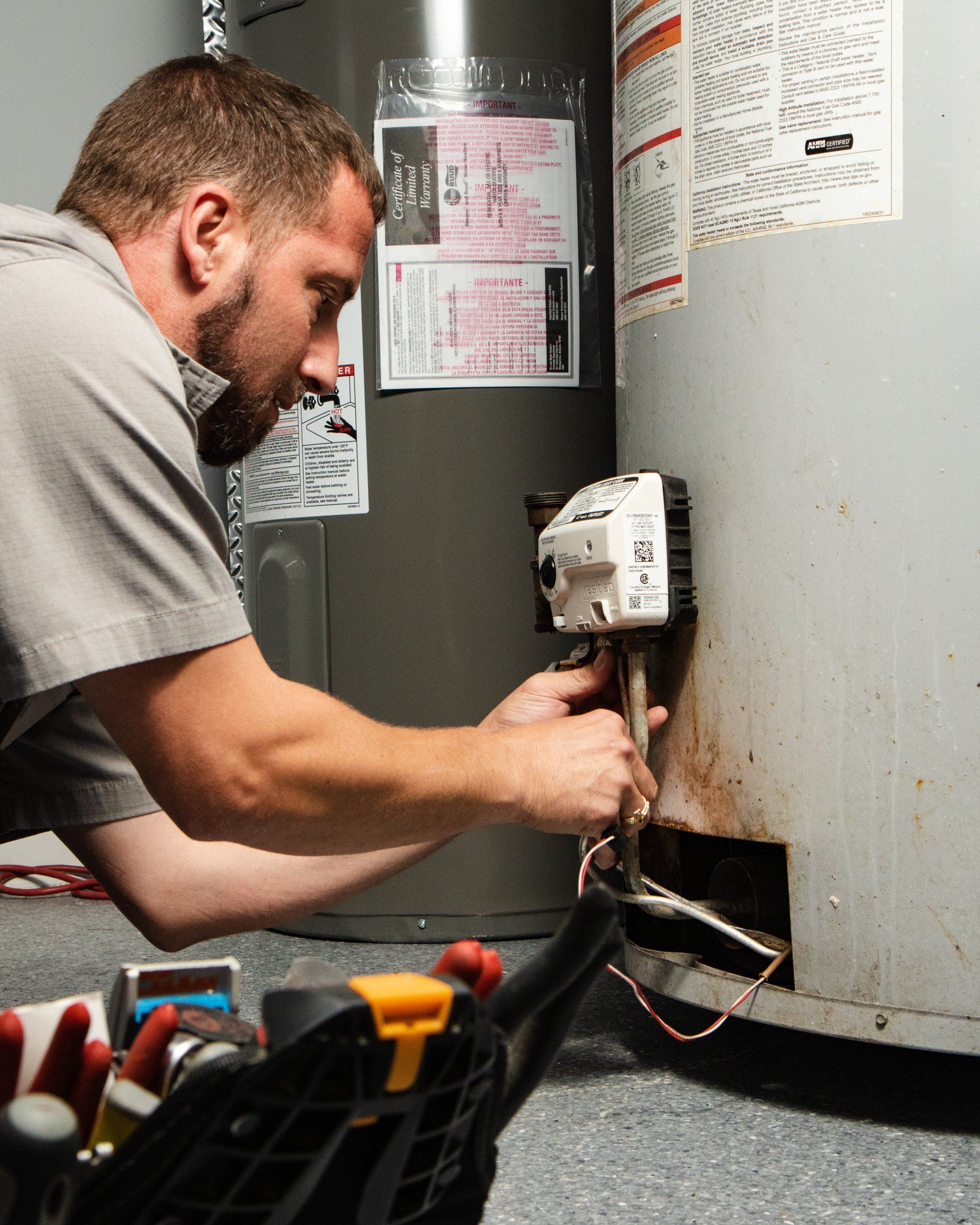 Water heater service technician working on gas valve