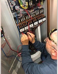 Técnico de servicio diagnosticando un calentador de agua eléctrico comercial