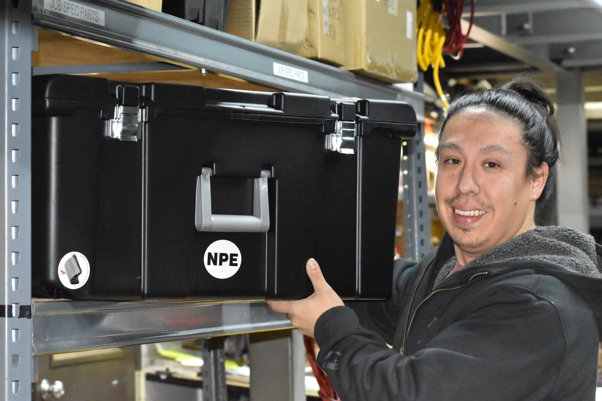 Manny holding a tankless water heater service bin