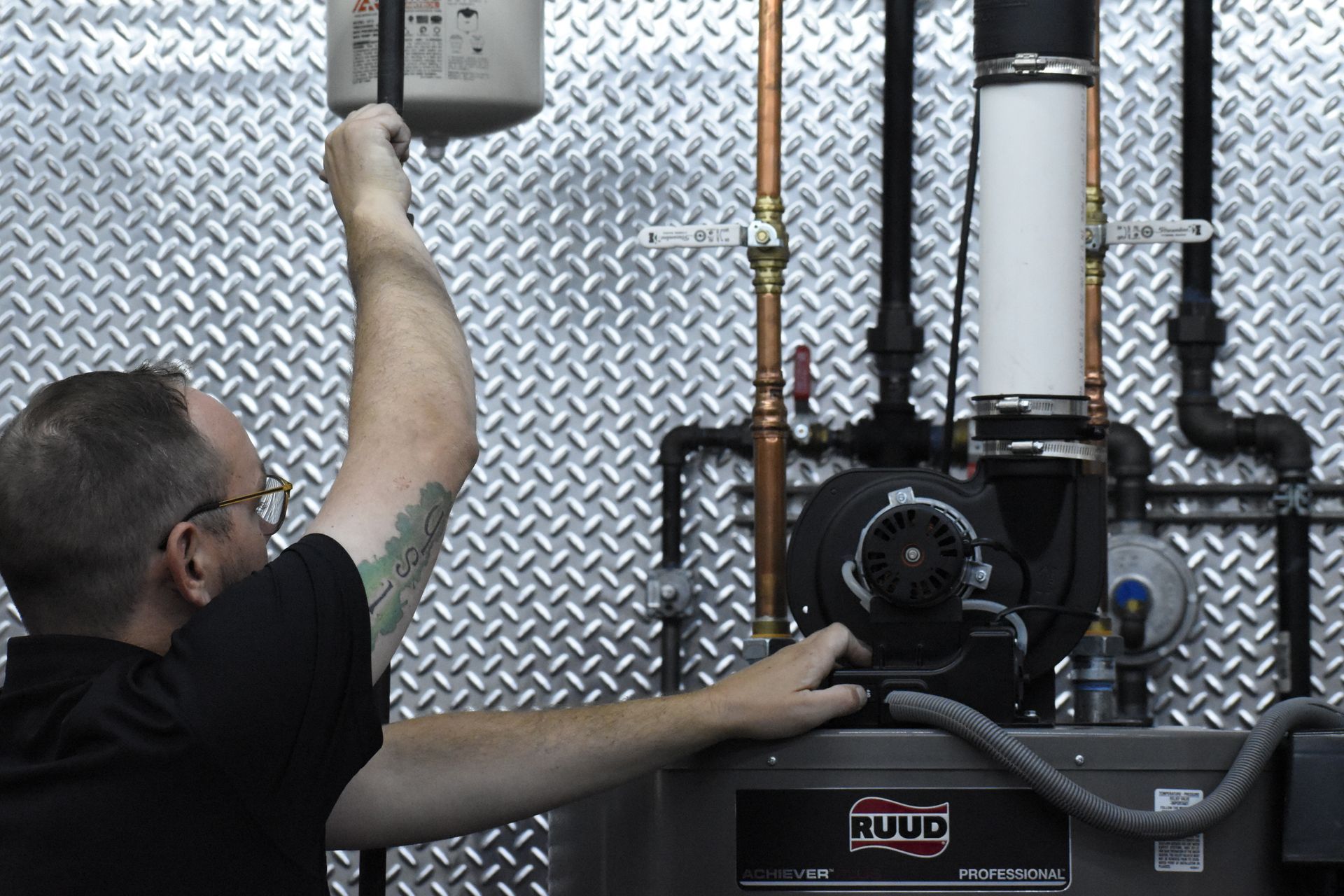 Water heater technician diagnosing issue with Ruud residential PowerVent, shutting off gas to the unit and turning off the blower assembly