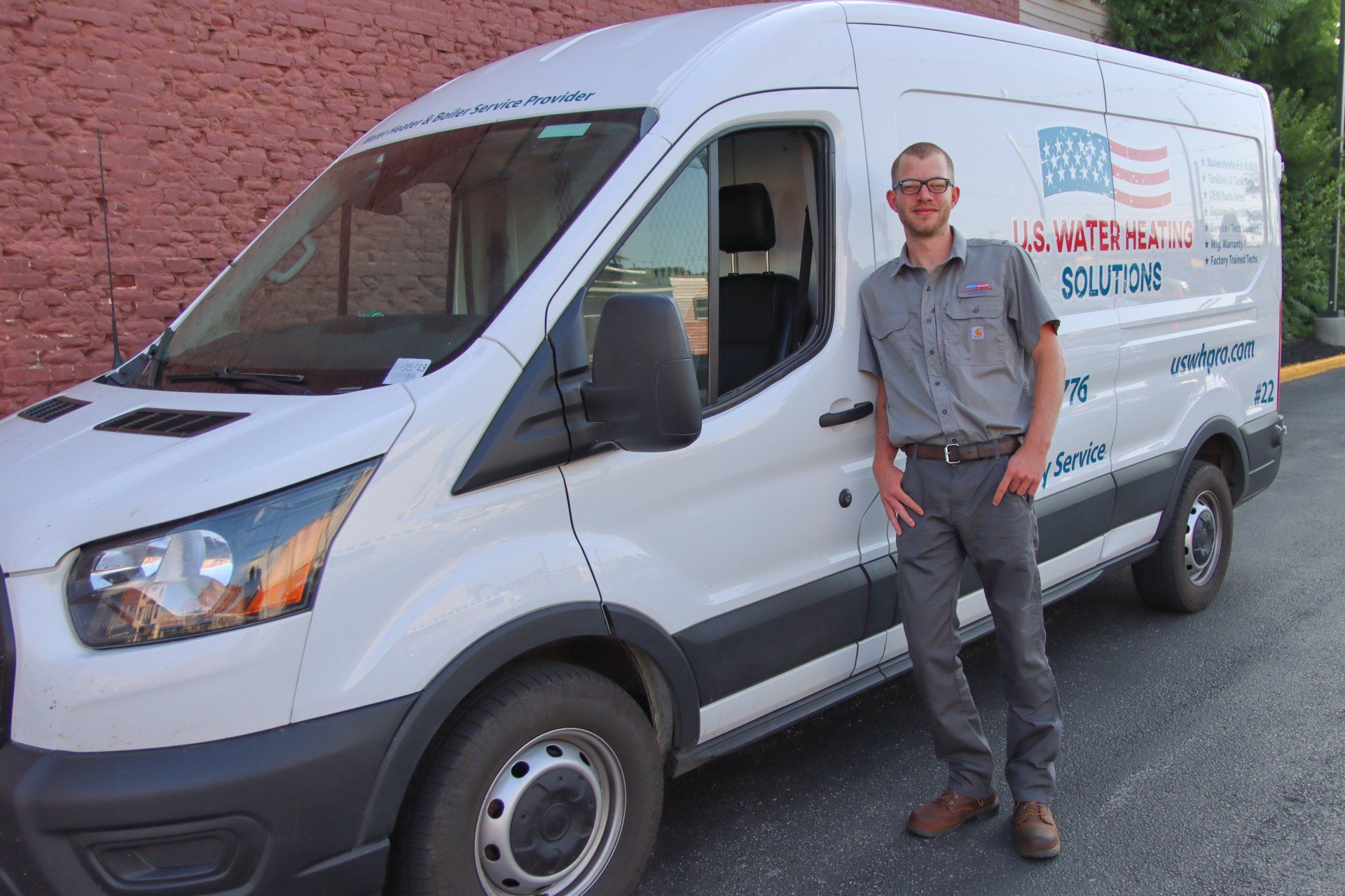 Wisconsin water heater repair technician leaning against his U.S. Water Heating Solutions company truck