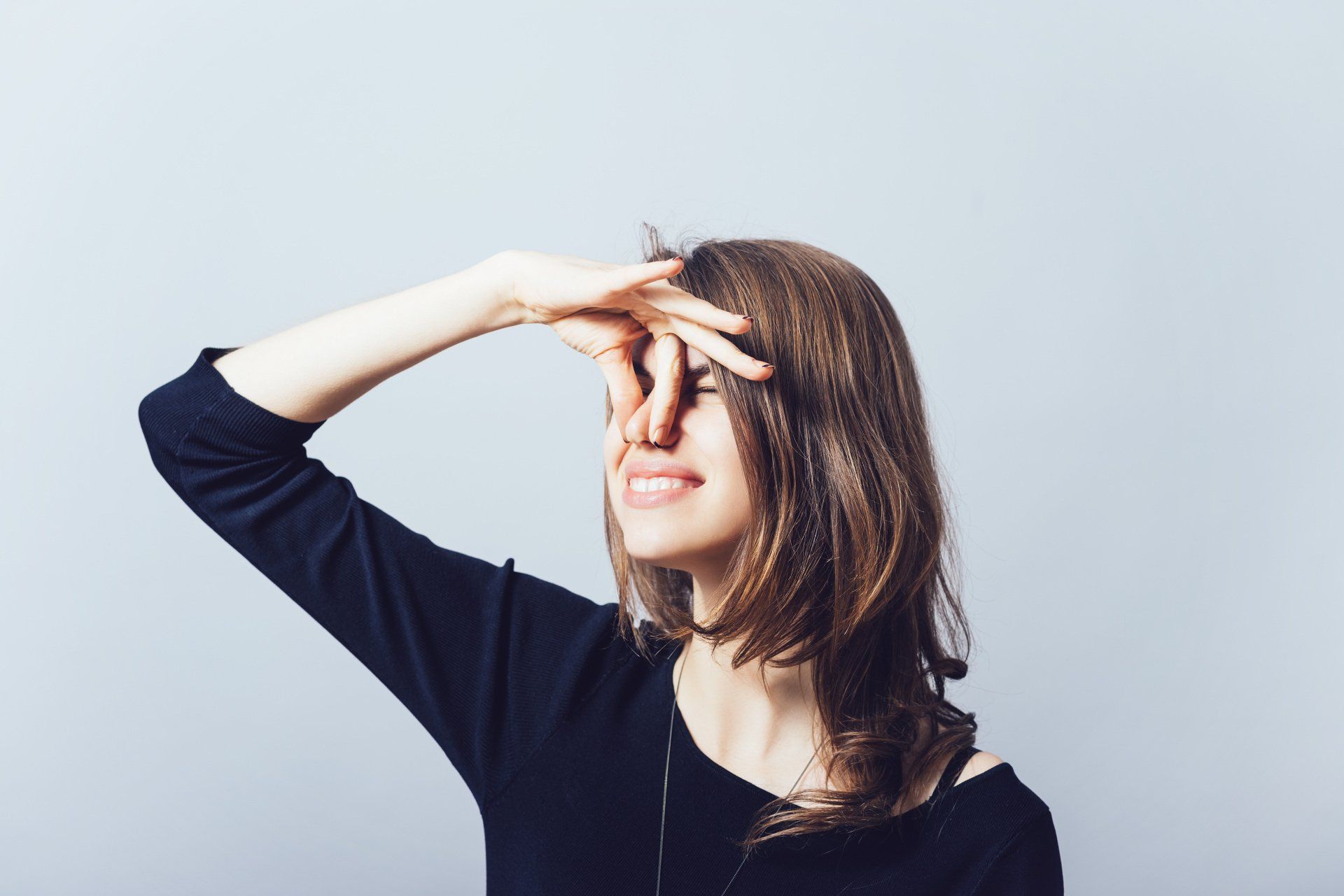woman pinching her nose closed