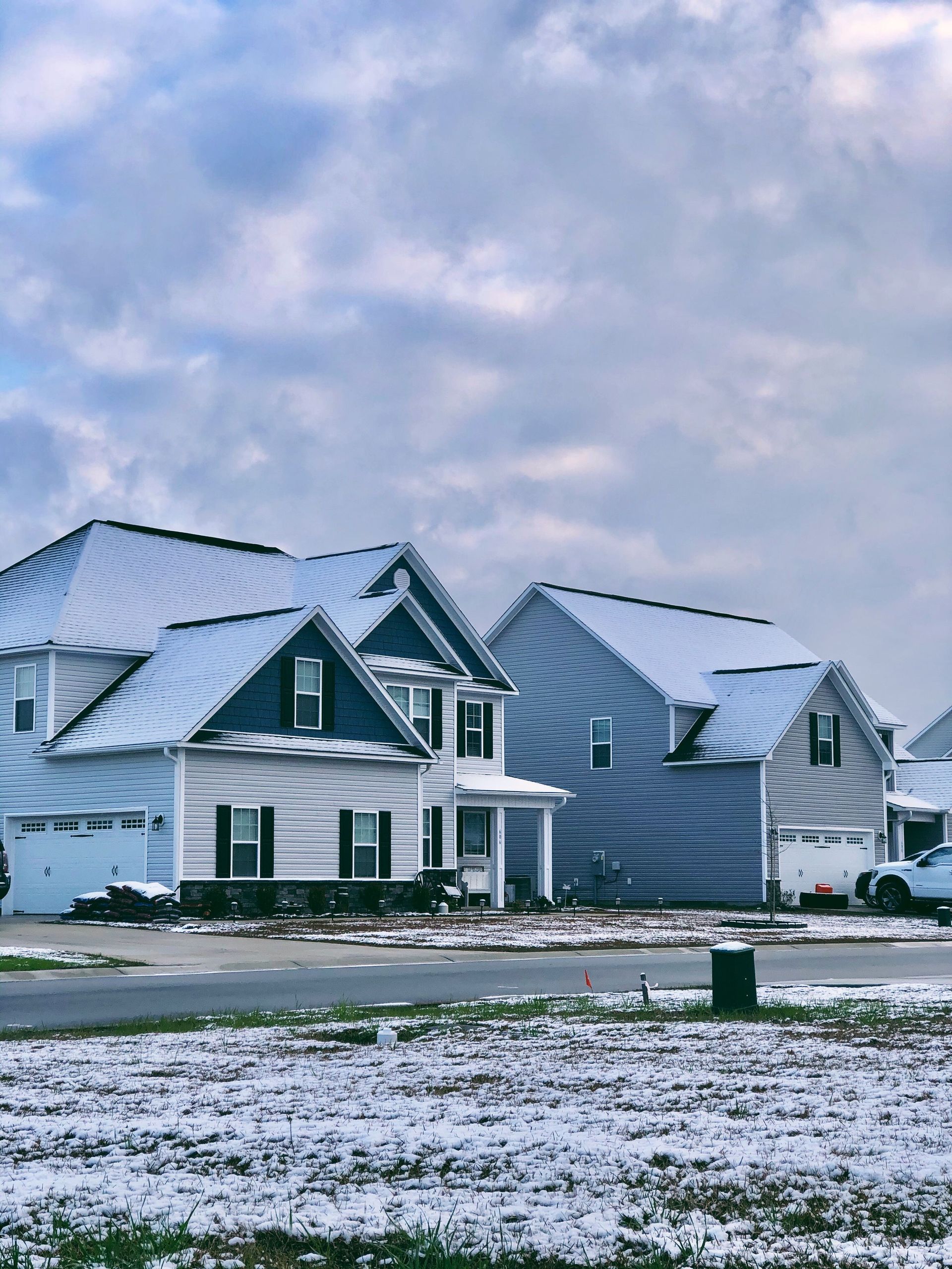 Single family home in the winter with snow on the grass and roof