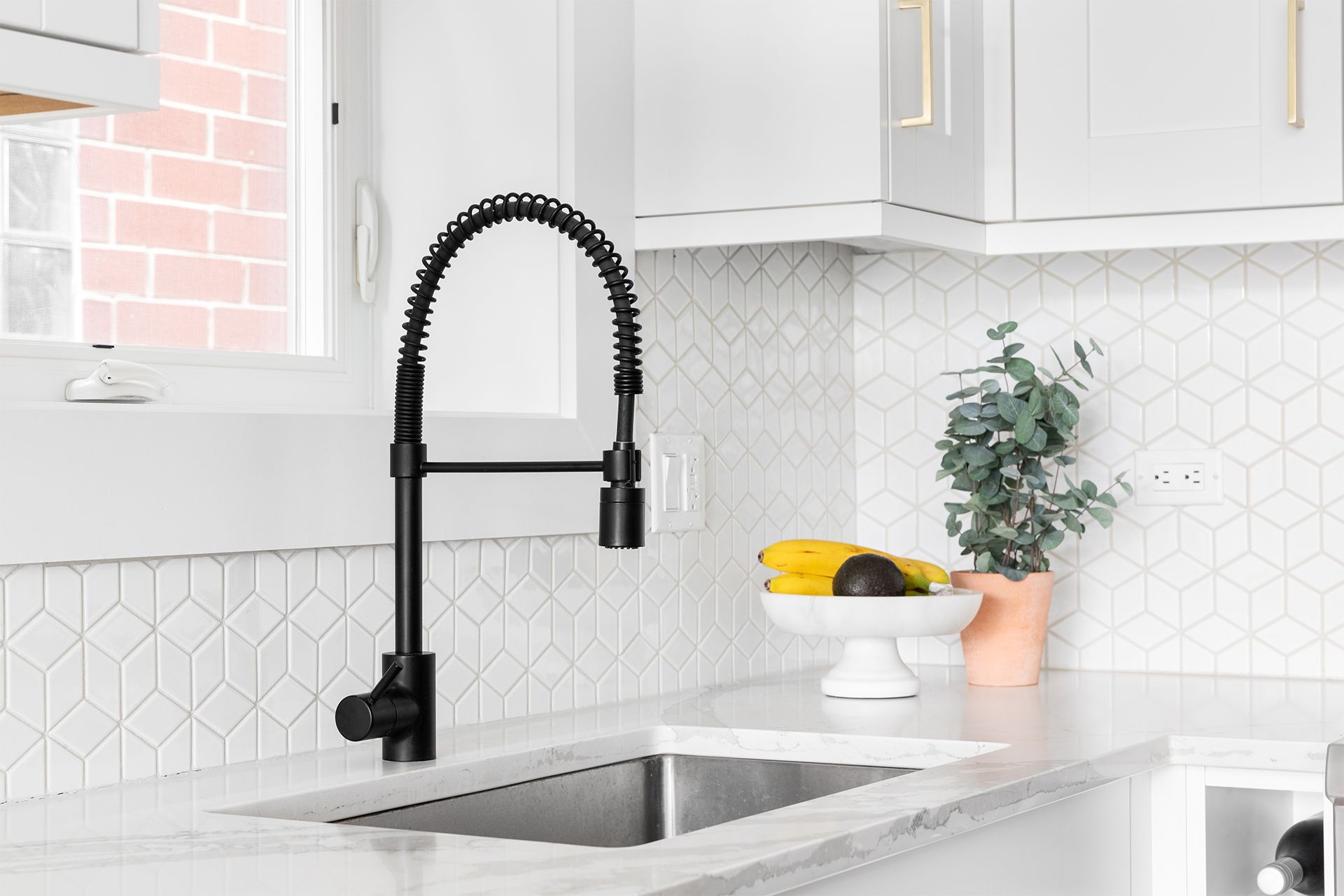 Kitchen with marble tile mosaic backsplash.