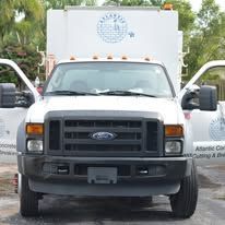 White box truck with open doors, viewed from the front in a parking lot.