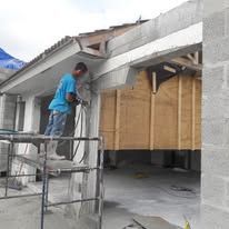 Worker on scaffold installing concrete formwork on a building exterior