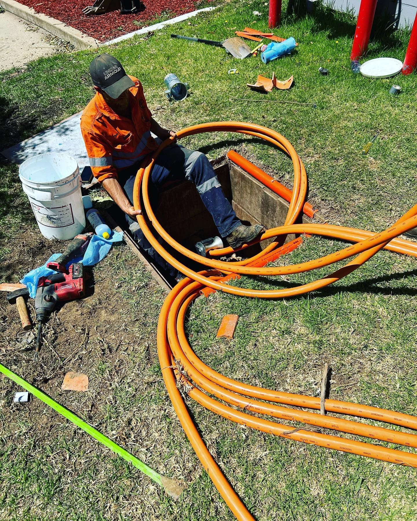 Man Working With Orange Cables in an Open Utility Access Point — Central West Power Construction in Orange, NSW