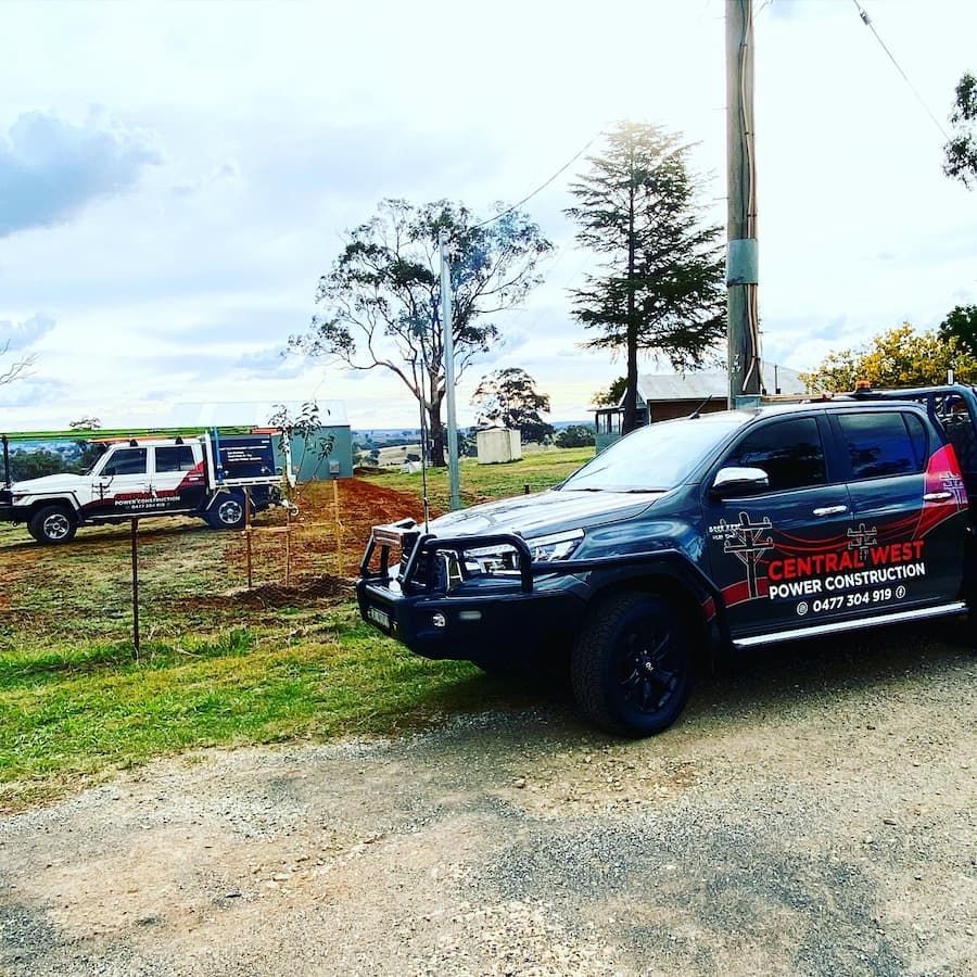 Two Work Trucks Parked Outdoors, One With Central West Power Construction — Central West Power Construction in Orange, NSW
