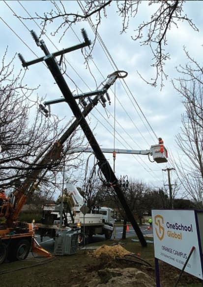 Power Lines and Pole Leaning at an Angle, With a Utility Truck and Worker — Central West Power Construction in Orange, NSW