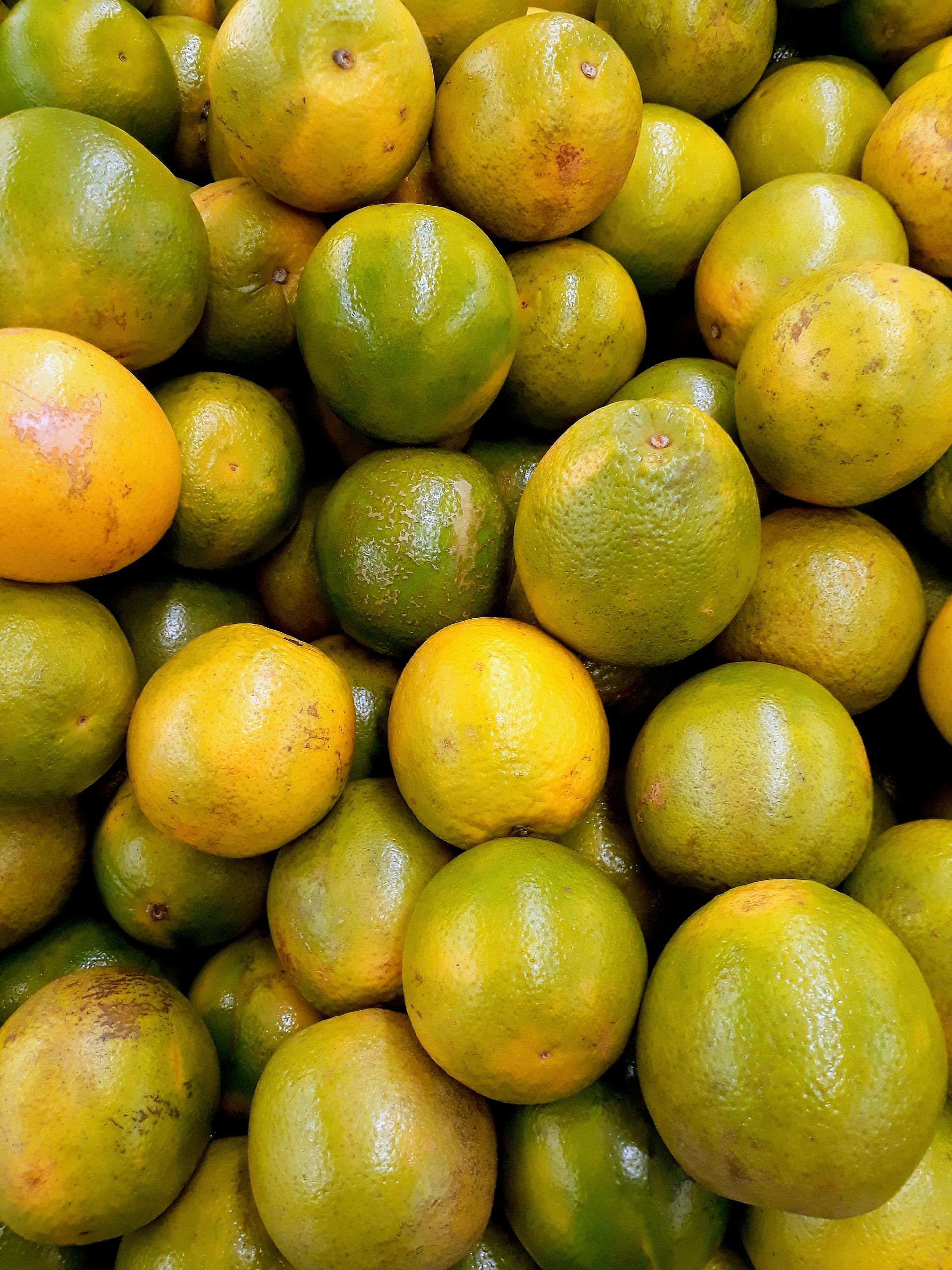 A bunch of oranges are stacked on top of each other
