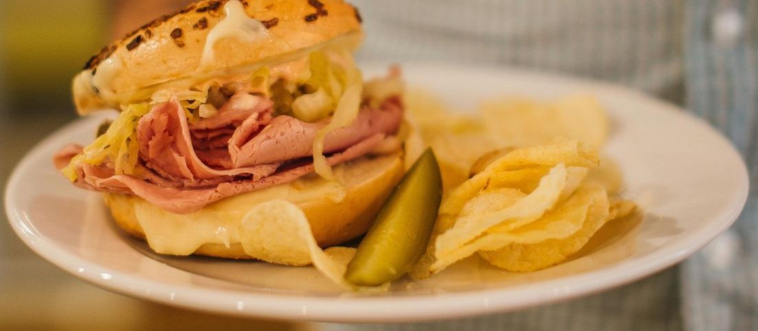  a plate of food with a sandwich and chips on it.