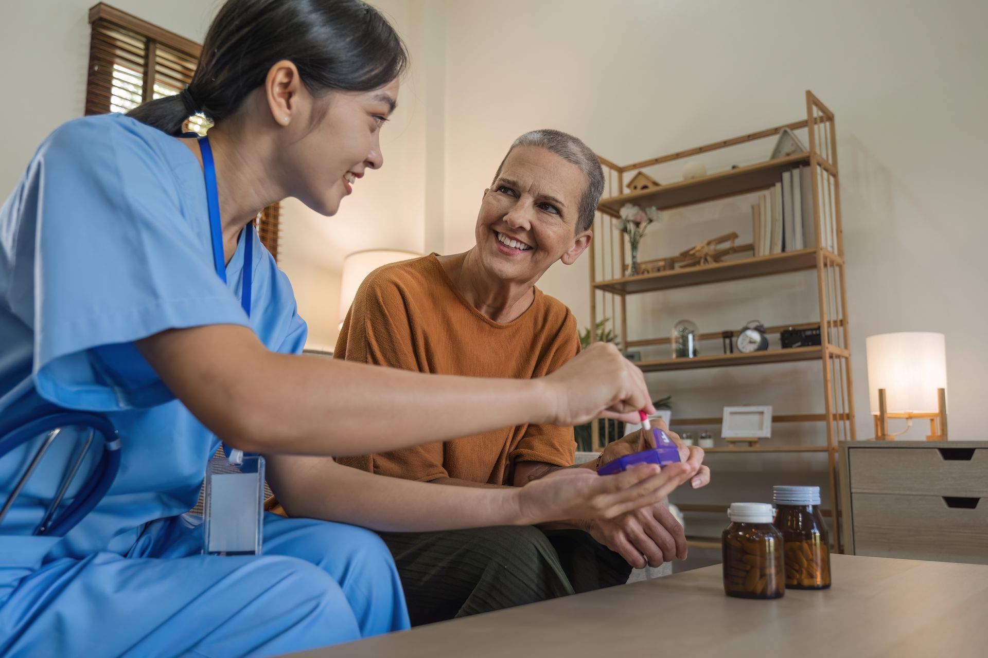 A caregiver helping an elderly man take his medication