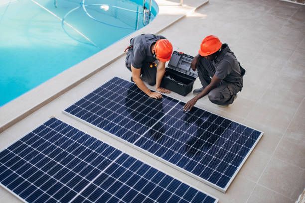 Two engineers with protective helmets preparing for installing solar panels.