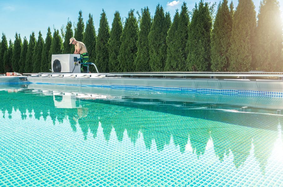 A man is working on an air conditioner in a swimming pool.