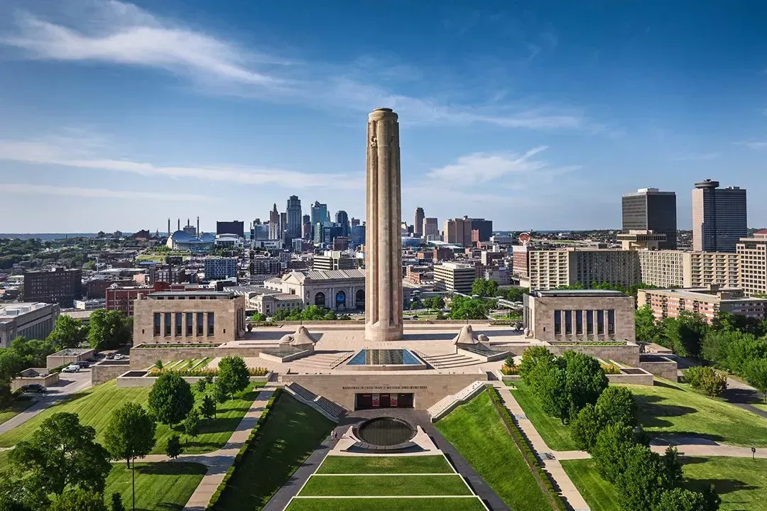 The National WWI Museum and Memorial stands prominently with its tall tower centered before the Kansas City skyline.