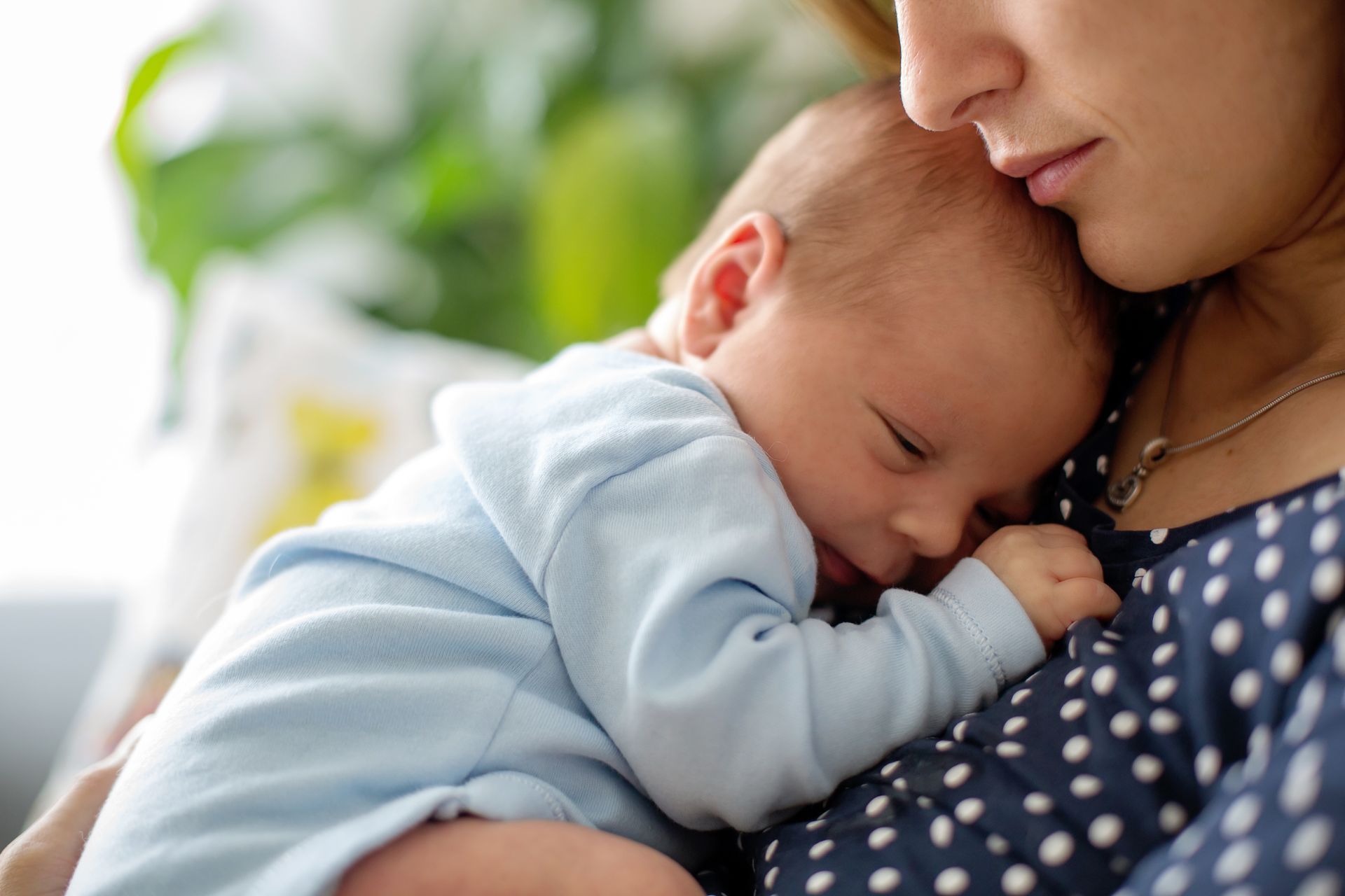 Mom holding newborn baby closely