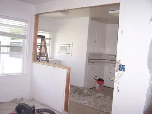 A room with a ladder and a vacuum cleaner in it.