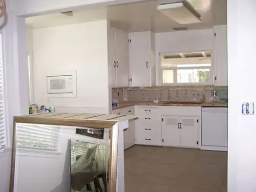 An empty kitchen with white cabinets and a dishwasher