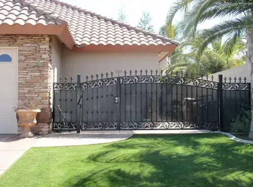 A house with a fence and a palm tree in front of it.