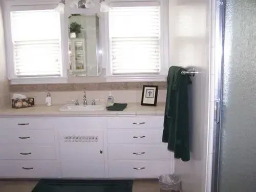 A bathroom with white cabinets and a sink