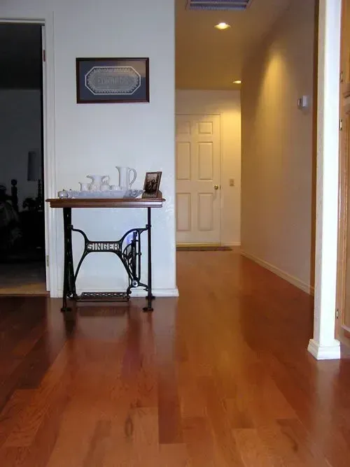 A hallway with hardwood floors and a sewing machine