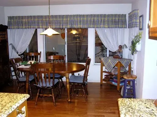 A dining room with a table and chairs and a sliding glass door