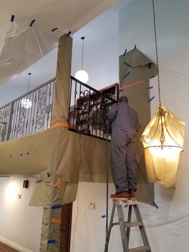 A man standing on a ladder in a room