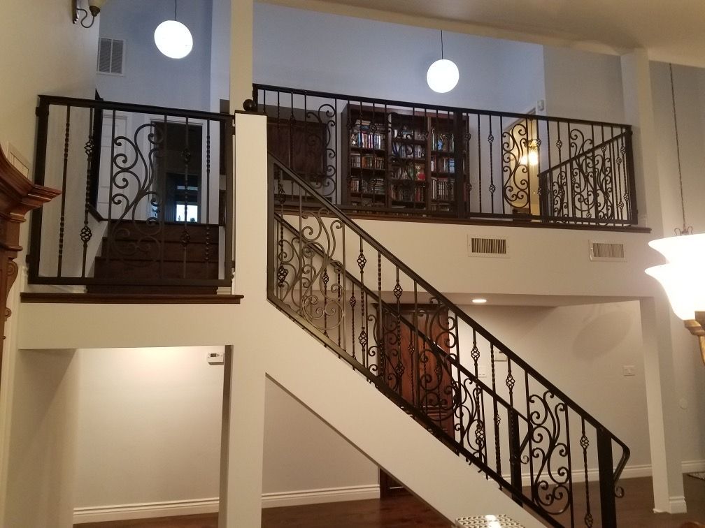 A staircase in a house with a wrought iron railing
