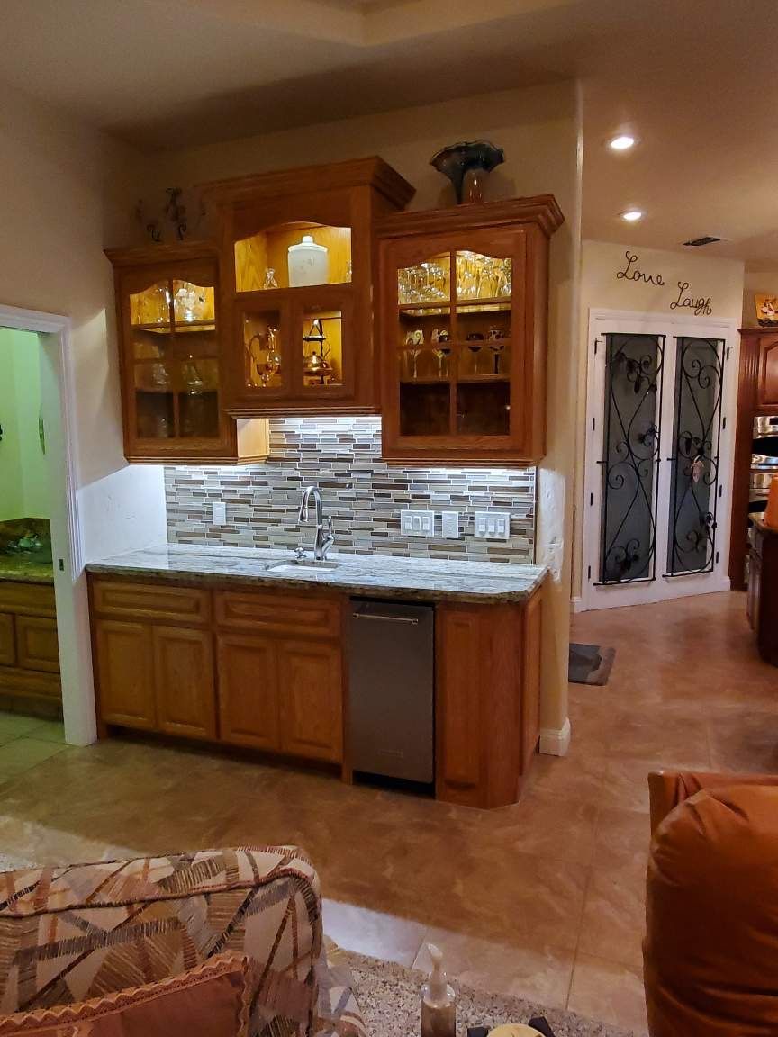A kitchen with wooden cabinets and a stainless steel dishwasher