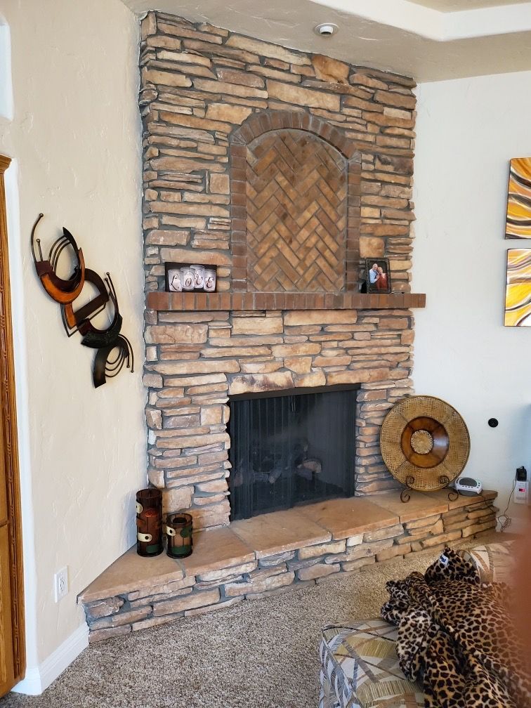 A living room with a stone fireplace and a leopard statue
