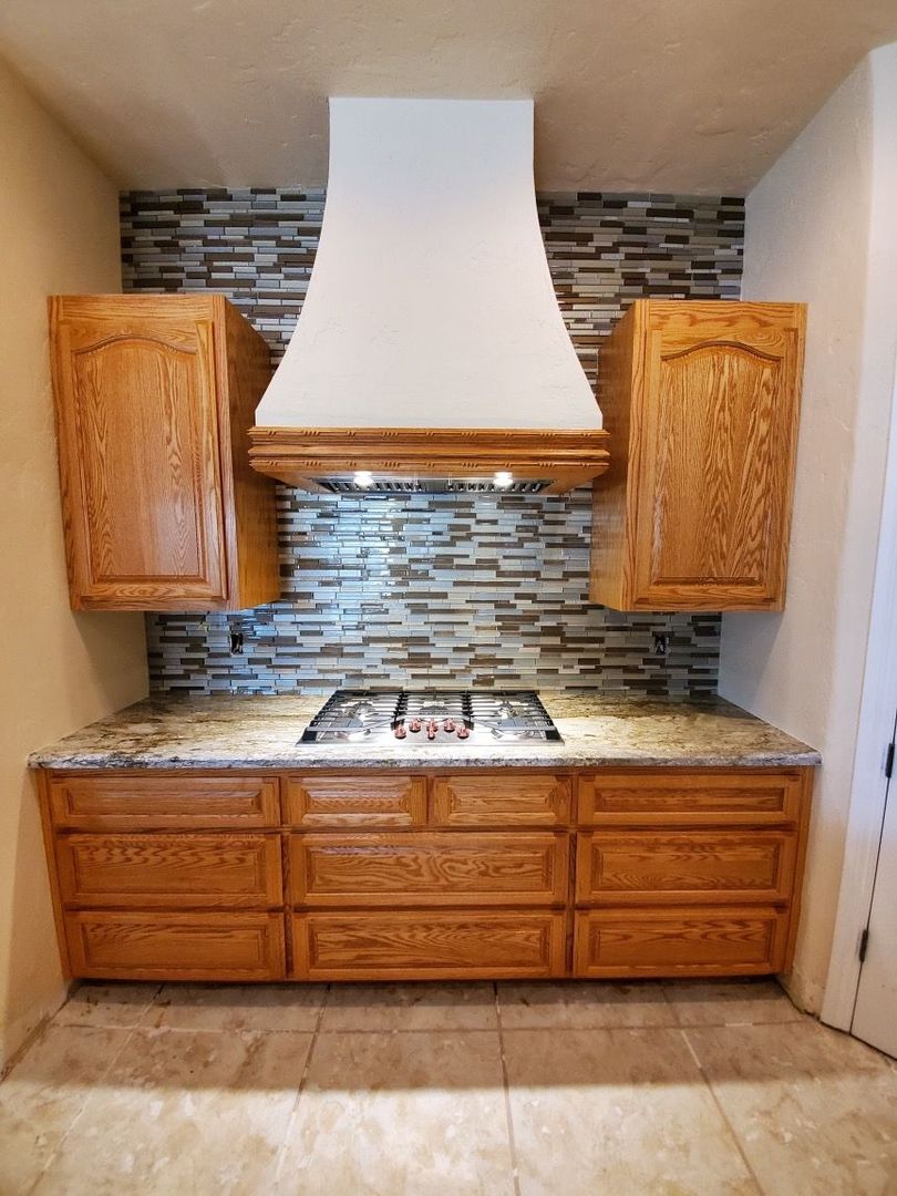 A kitchen with wooden cabinets and a stove top oven