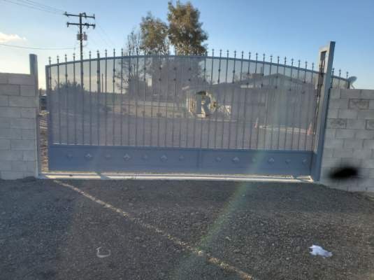 A sliding gate with a brick wall behind it