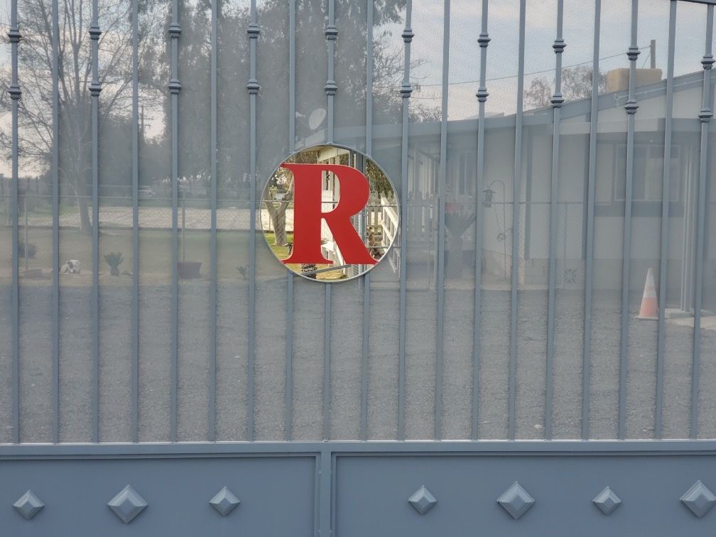 A metal fence with a red letter r on it