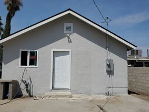 A gray house with a white door and a window