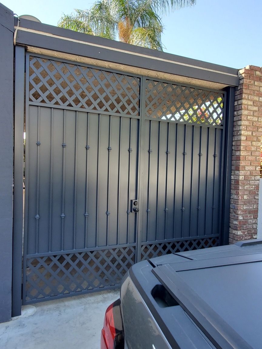 A black truck is parked in front of a black gate