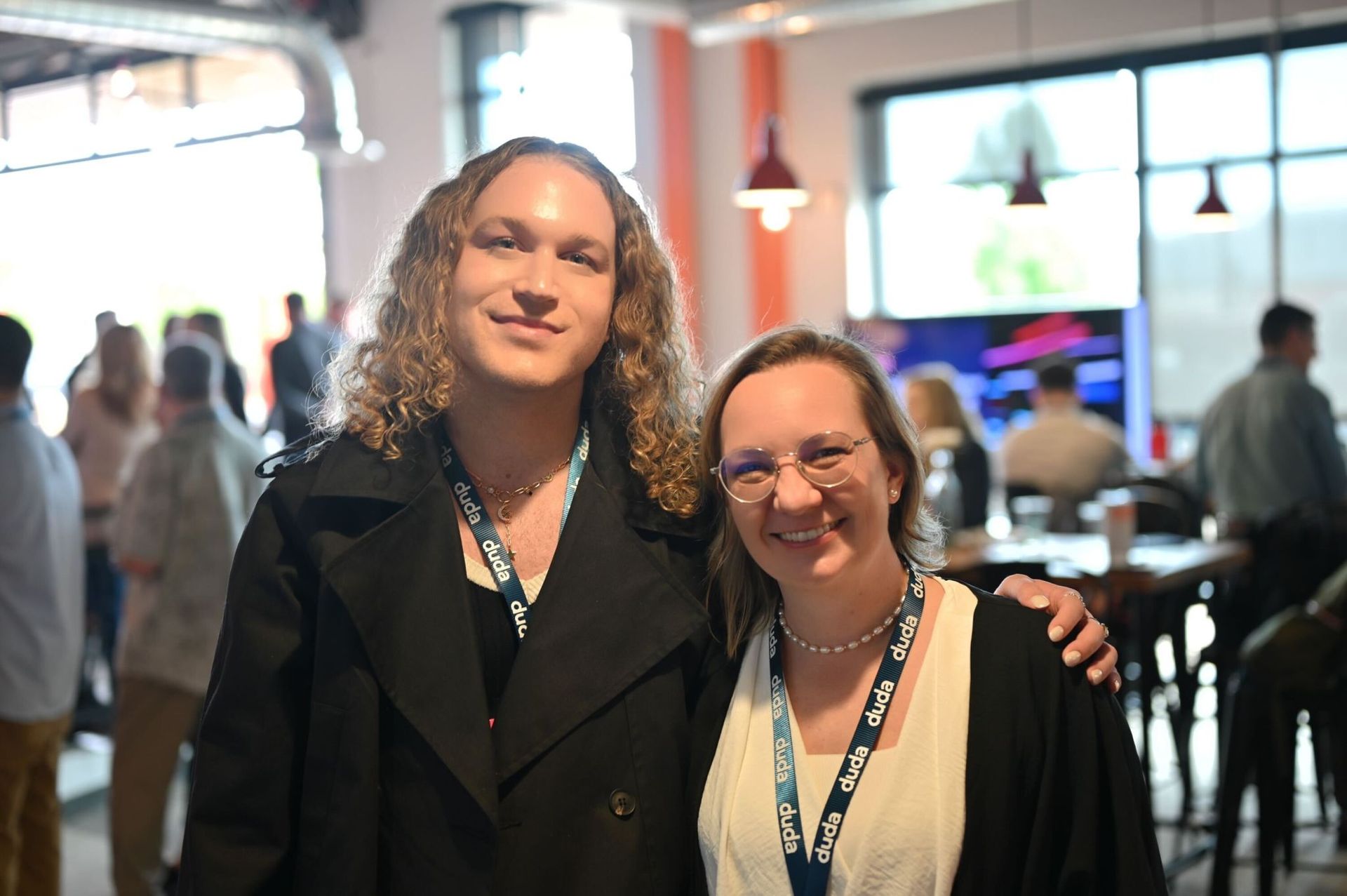 A man and a woman are posing for a picture in a restaurant.