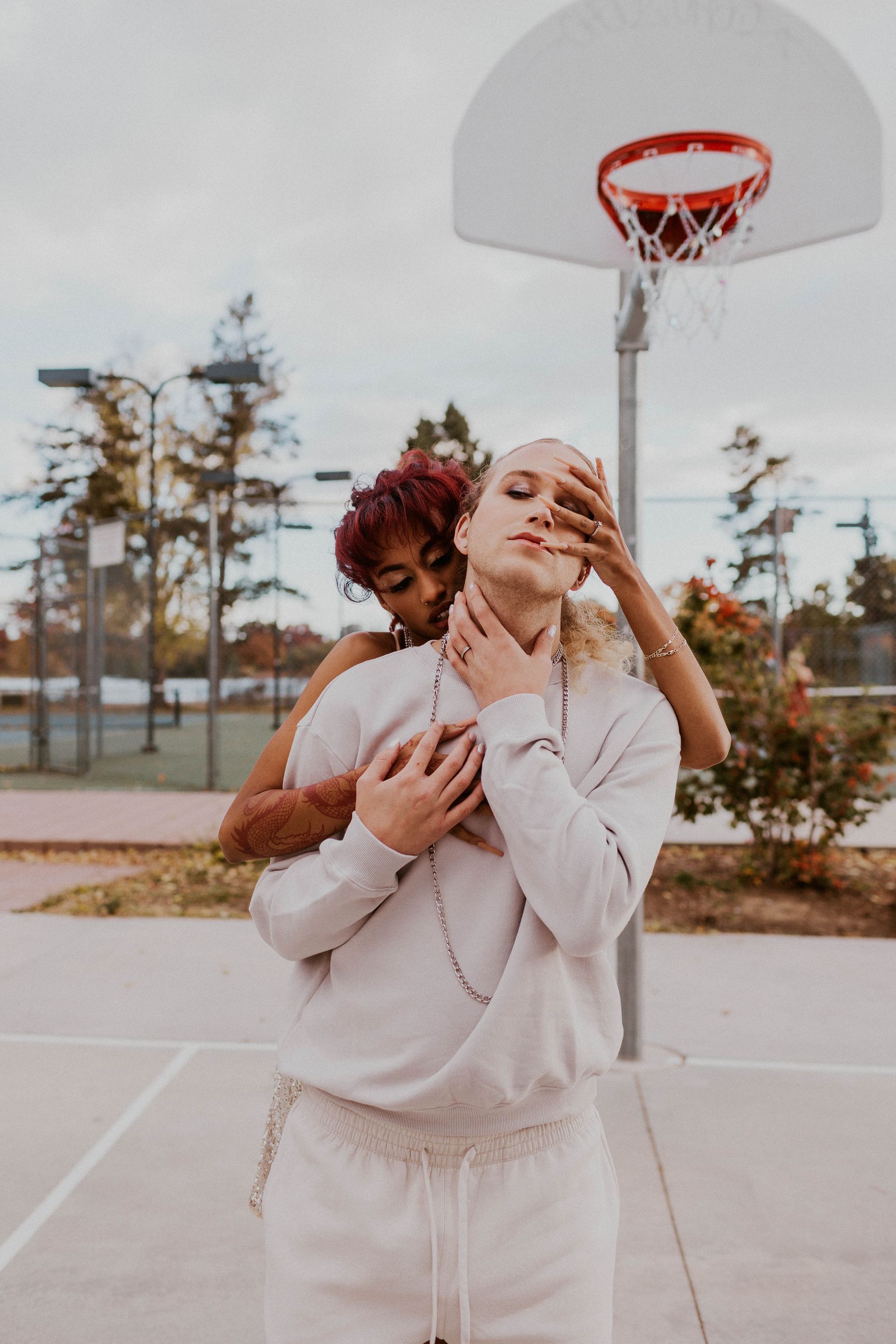 A woman is hugging a man on a basketball court.
