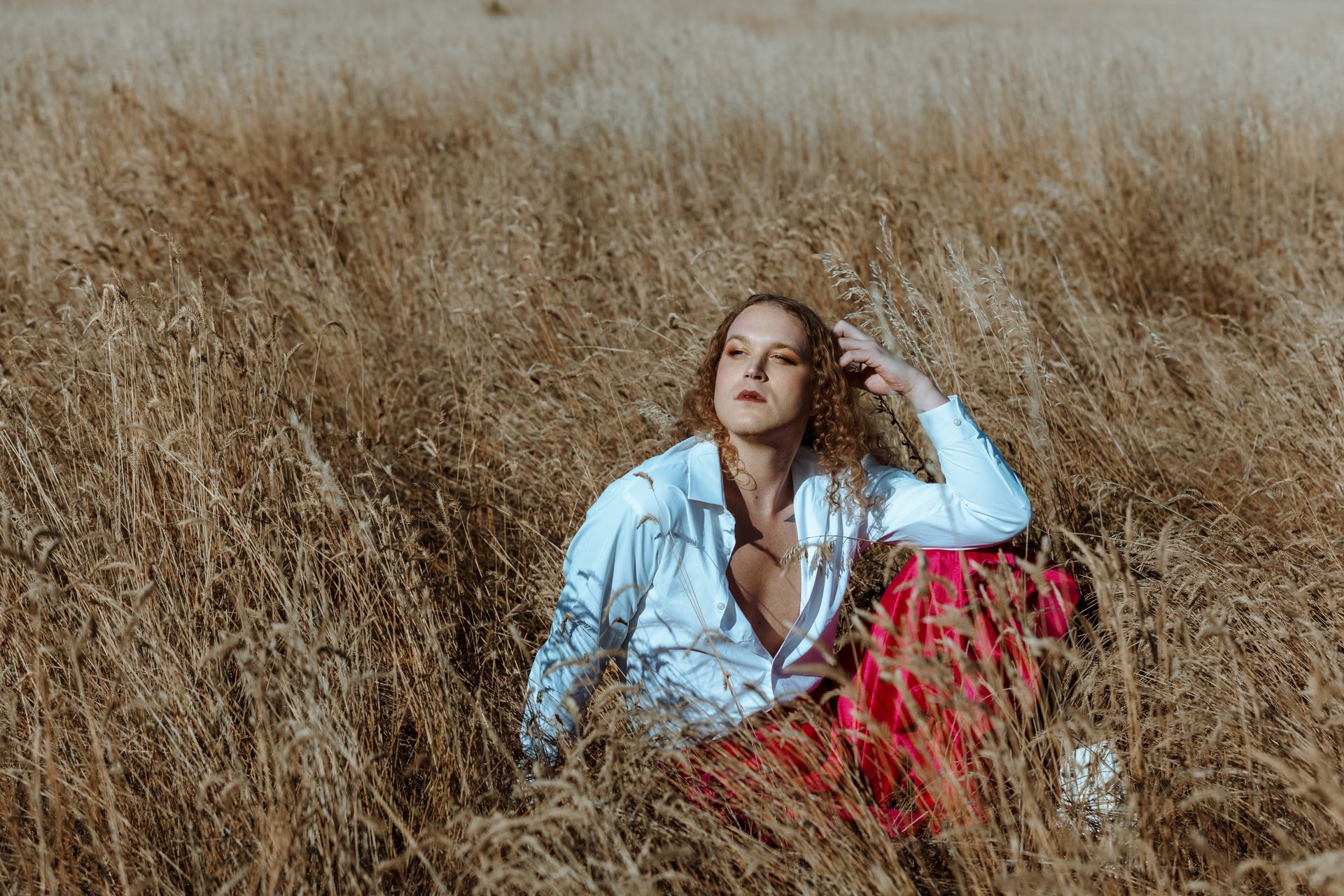 Scotty Strehlow is sitting in a field of tall grass for a photo shoot.