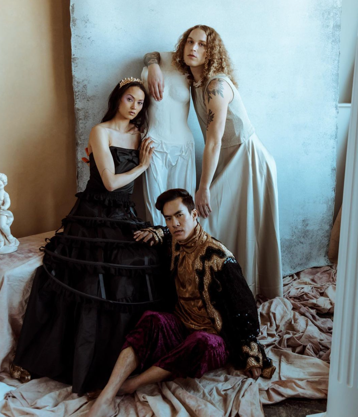 A man and two women are posing for a picture together for a fashion photo shoot.