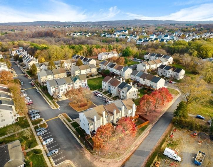 Aerial view of a suburban apartment complex with autumn trees and a parking lot nearby