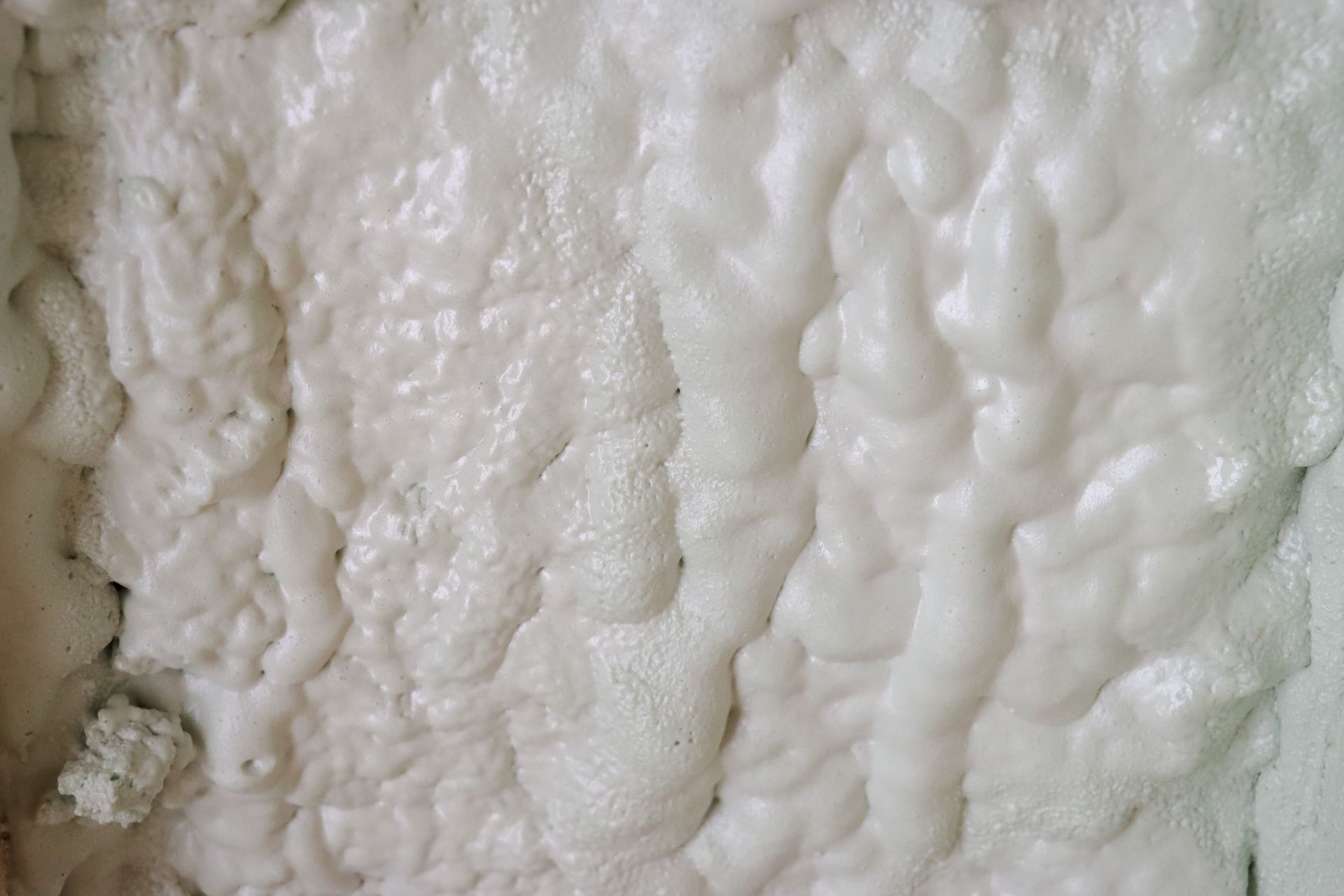 A close up of a white foam on a wall.