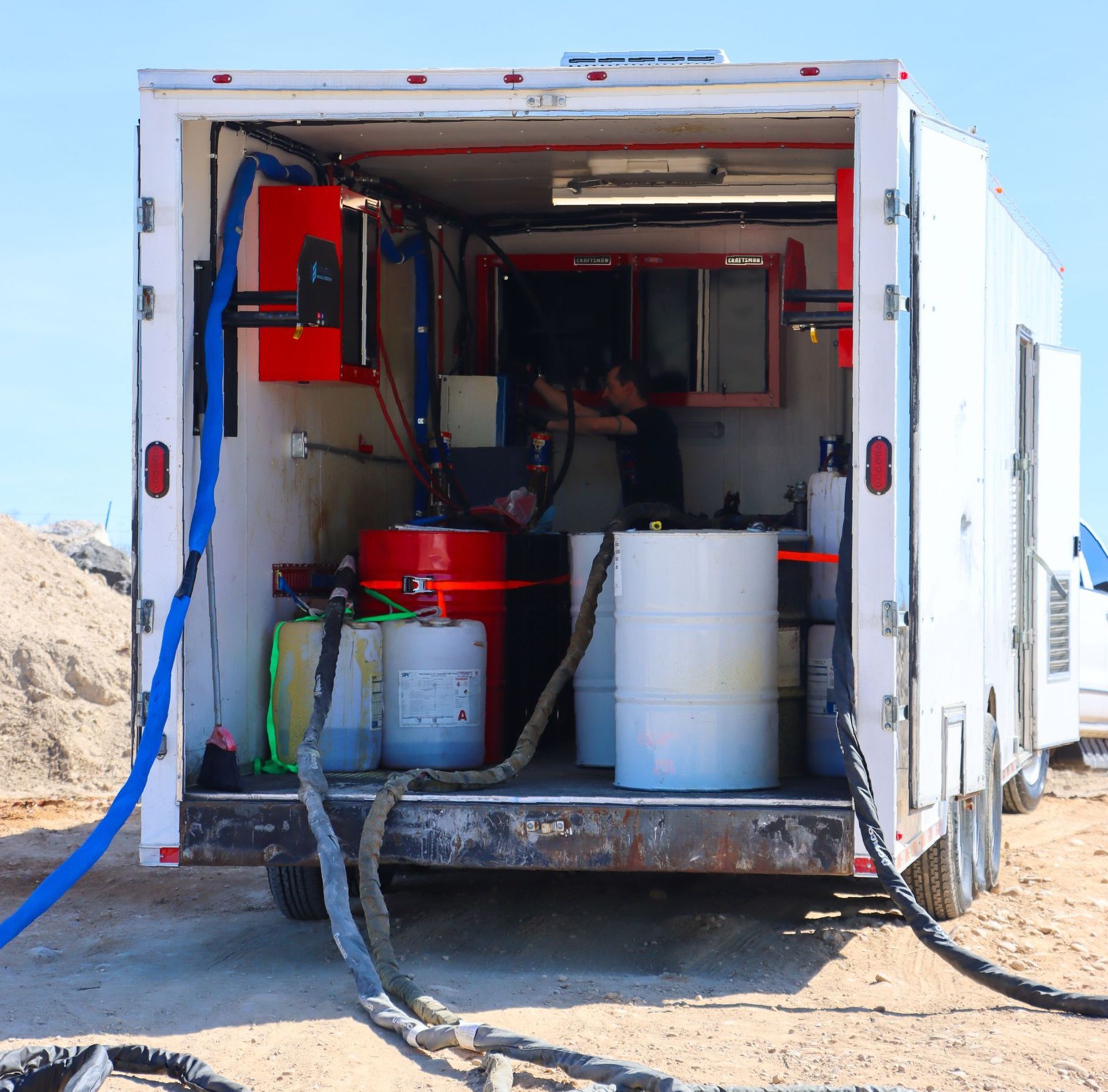 A white trailer with a hose attached to it