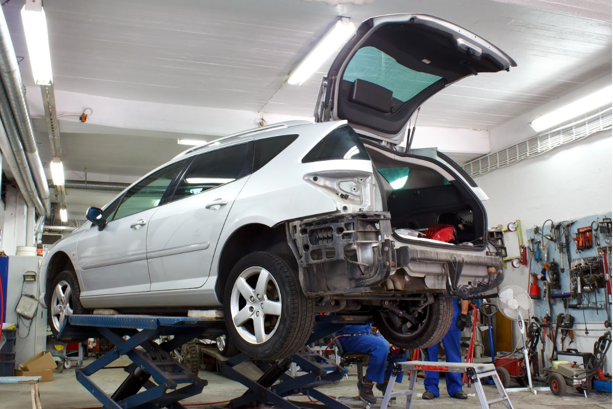 Mechanic working on car in auto body shop