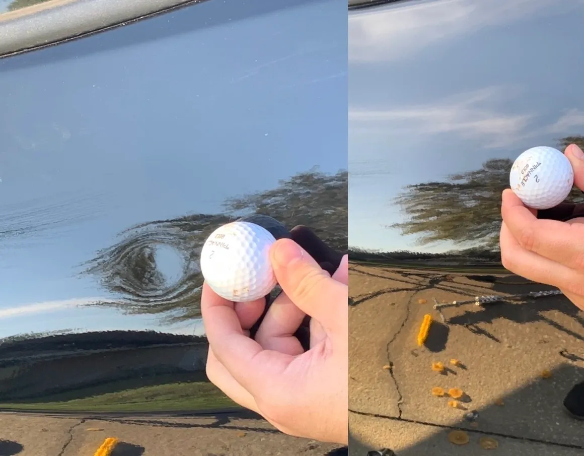 Golf ball next to dent on car door, sunny outdoors.